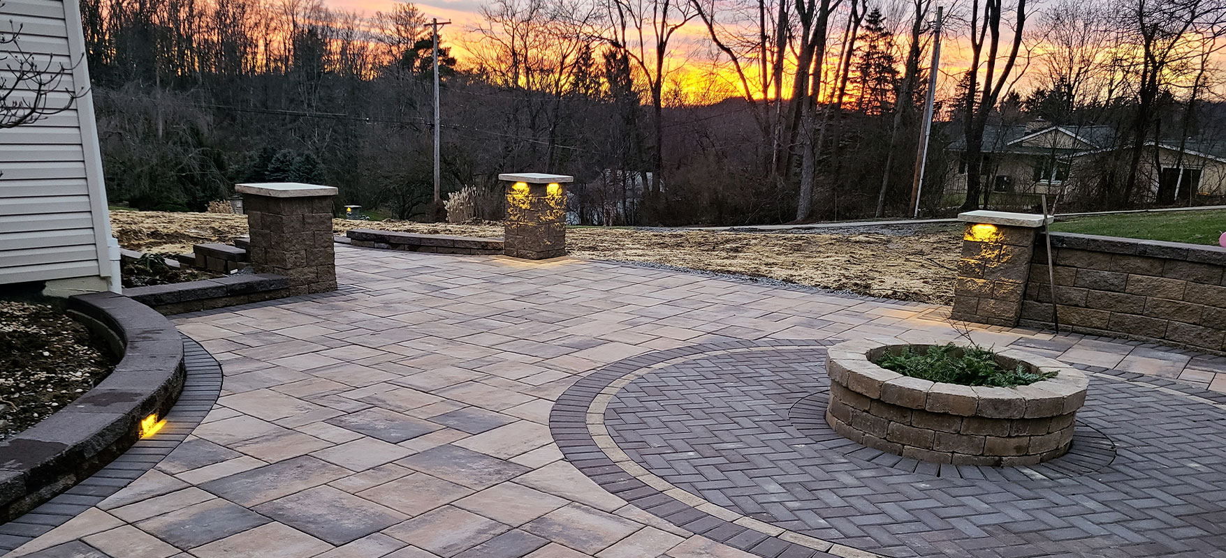 McGinn Hardscaping - Unilock Beacon Hill Flagstone in walnut with mocha Holland stone inlay Castlerock fire pit